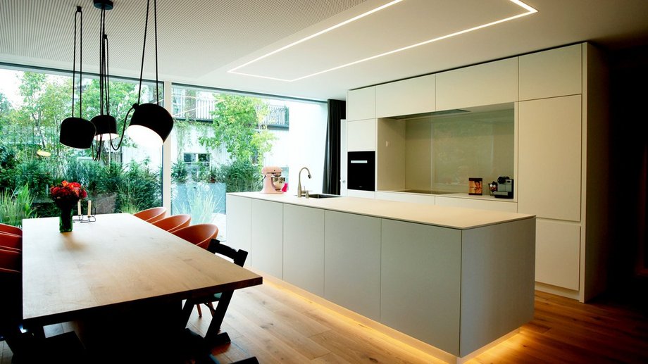 Moderne Küche mit Bodenbeleuchtung und weisser Ablage.