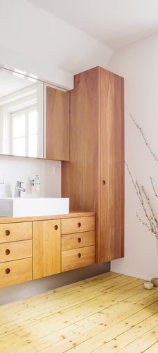 Moderne Holzmöbel in einem Badezimmer mit Holzfussboden.