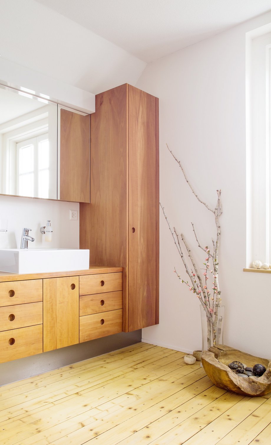 Moderne Holzmöbel in einem Badezimmer mit Holzfussboden.